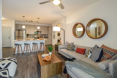 a living room with a couch and a kitchen with a bar